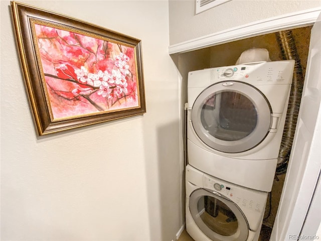 clothes washing area featuring stacked washer / drying machine