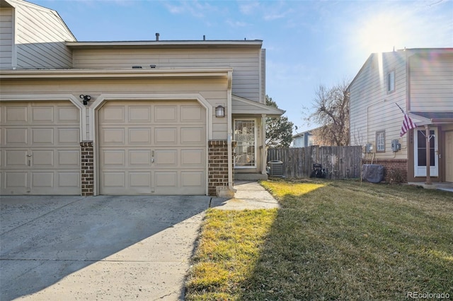 view of front facade featuring driveway, central AC unit, fence, a front lawn, and brick siding