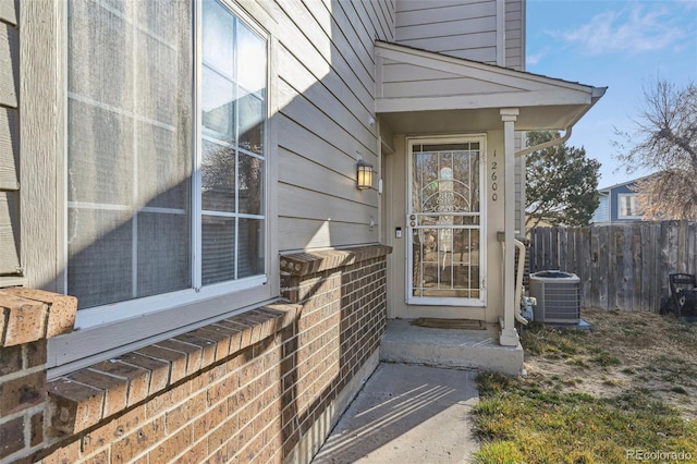 entrance to property with cooling unit and fence