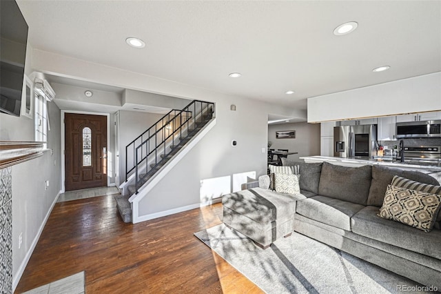 living room featuring recessed lighting, stairway, baseboards, and wood finished floors