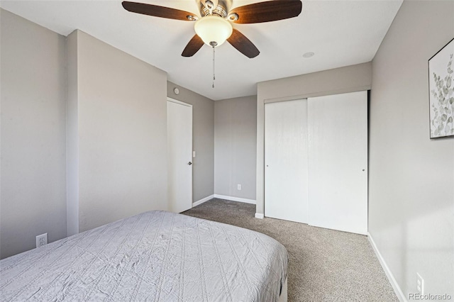 carpeted bedroom featuring ceiling fan, a closet, and baseboards