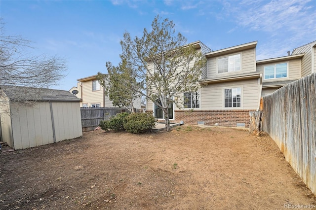 back of house with an outbuilding, brick siding, crawl space, a shed, and a fenced backyard