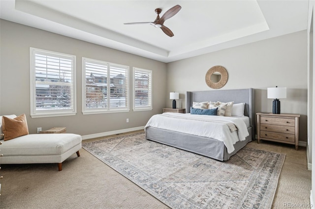 bedroom with ceiling fan and a tray ceiling