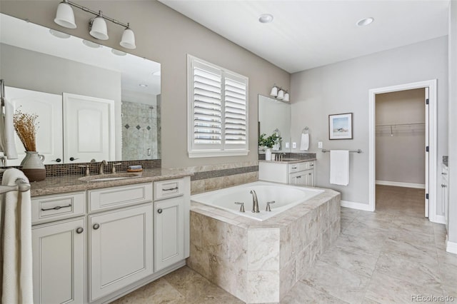 bathroom featuring vanity and independent shower and bath