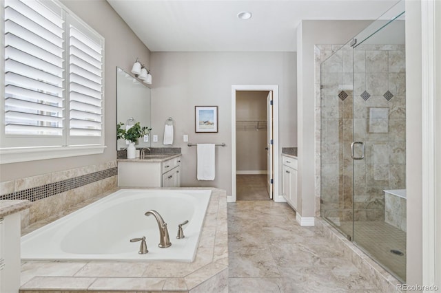 bathroom with vanity and shower with separate bathtub