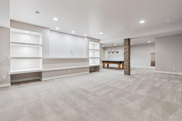 unfurnished living room with built in shelves and light carpet