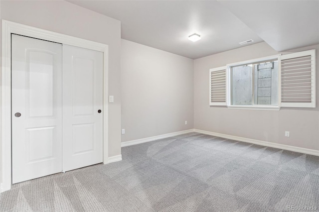 unfurnished bedroom with a closet and light carpet