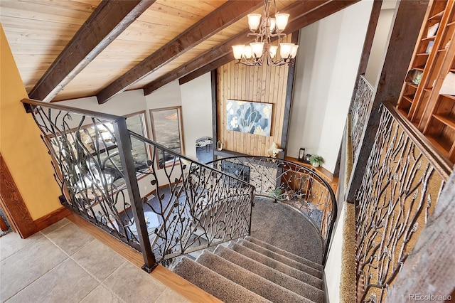 stairs featuring vaulted ceiling with beams, wooden walls, wood ceiling, baseboards, and an inviting chandelier