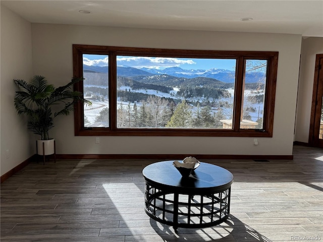 living area featuring baseboards, a mountain view, and dark wood-type flooring