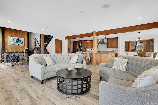 living area featuring a notable chandelier, stairway, recessed lighting, and light wood-style floors