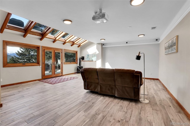 living room featuring french doors, light wood finished floors, visible vents, and baseboards