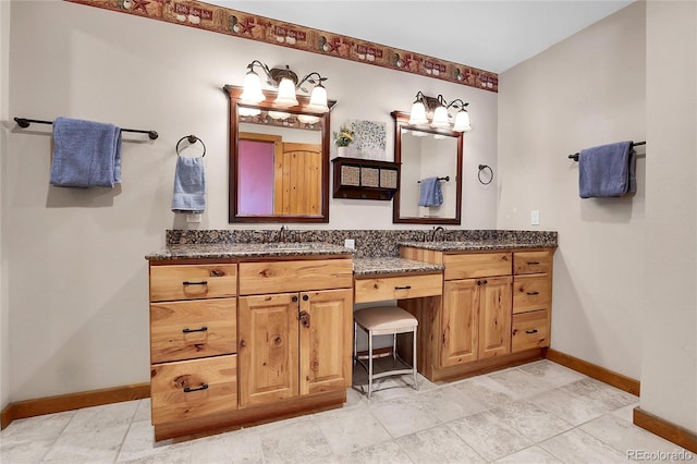 bathroom featuring double vanity, baseboards, and a sink