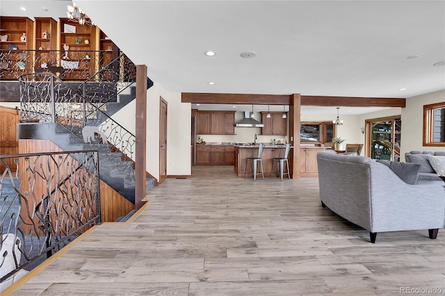 living room featuring a chandelier, recessed lighting, light wood-style flooring, and stairway