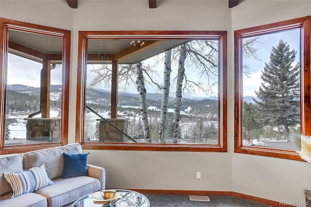 sunroom / solarium with visible vents, a mountain view, and a healthy amount of sunlight