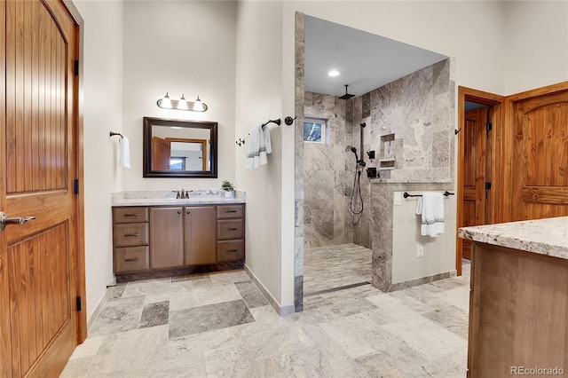 bathroom featuring baseboards, a walk in shower, and vanity