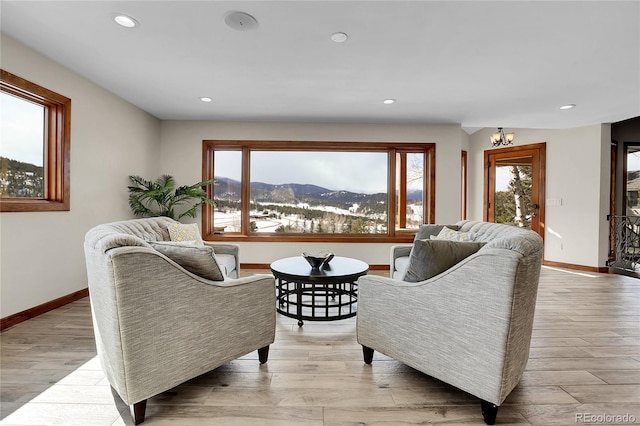 living area with recessed lighting, baseboards, a mountain view, and light wood finished floors