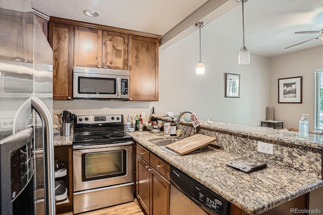 2838 Decatur St, Denver, CO 80211 - kitchen featuring stainless steel appliances, a sink, a peninsula, a ceiling fan, and light stone counters