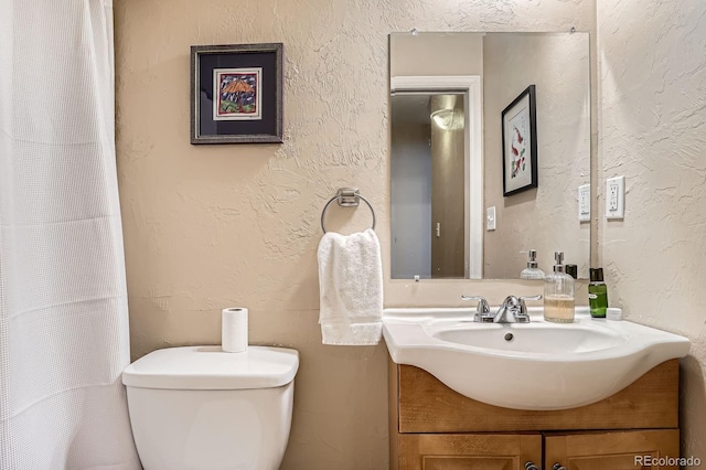 2838 Decatur St, Denver, CO 80211 - bathroom featuring vanity, toilet, a textured wall, and a shower with shower curtain