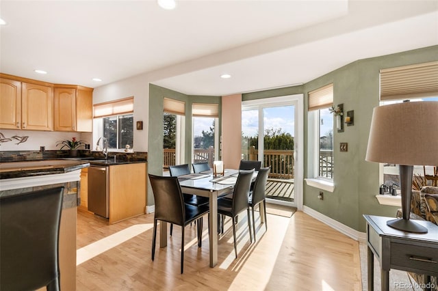 dining space with sink and light hardwood / wood-style floors