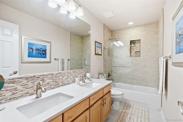 full bathroom with tiled shower / bath, decorative backsplash, vanity, toilet, and tile patterned floors