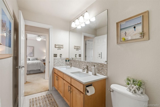 bathroom with vanity, toilet, tile patterned flooring, and backsplash