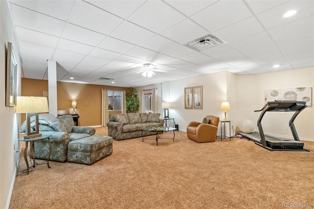 carpeted living room with a drop ceiling