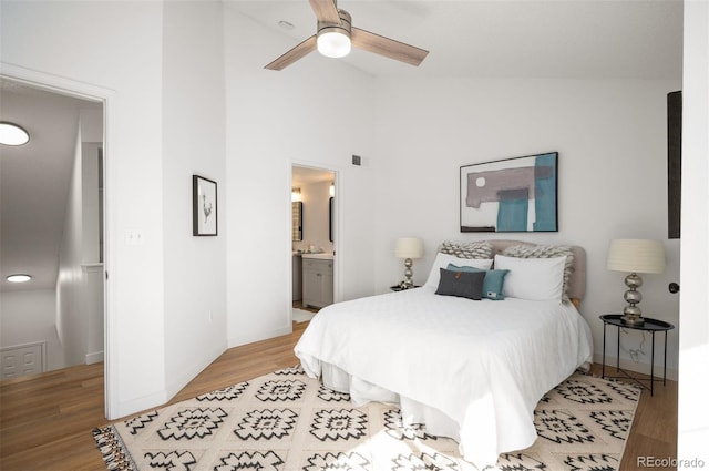 bedroom with high vaulted ceiling, ensuite bath, light hardwood / wood-style floors, and ceiling fan