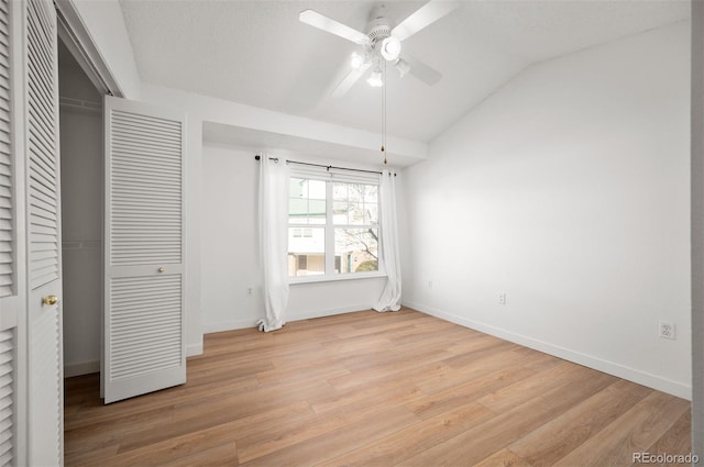 unfurnished bedroom with vaulted ceiling, ceiling fan, light hardwood / wood-style floors, a textured ceiling, and a closet