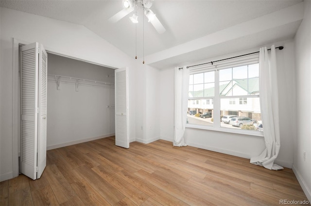 unfurnished bedroom featuring lofted ceiling, light hardwood / wood-style floors, a closet, and ceiling fan