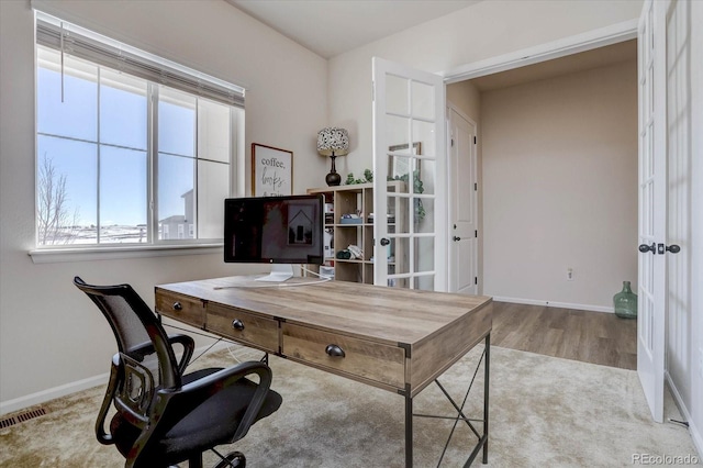 office with light hardwood / wood-style floors and french doors