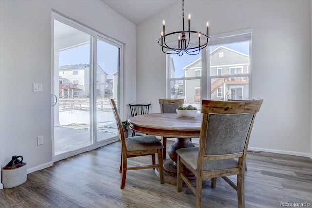 dining area with dark wood-type flooring and a chandelier