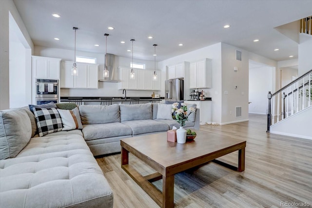 living room with sink and light hardwood / wood-style flooring