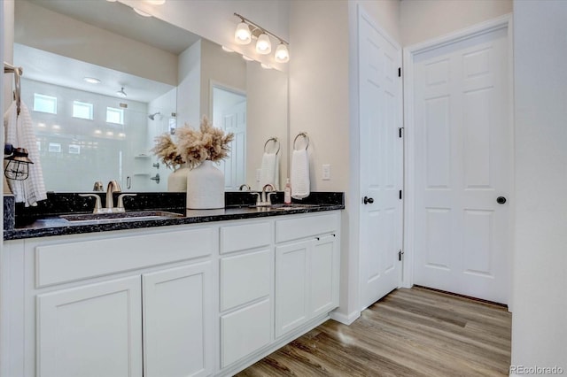 bathroom with a shower, vanity, and hardwood / wood-style flooring