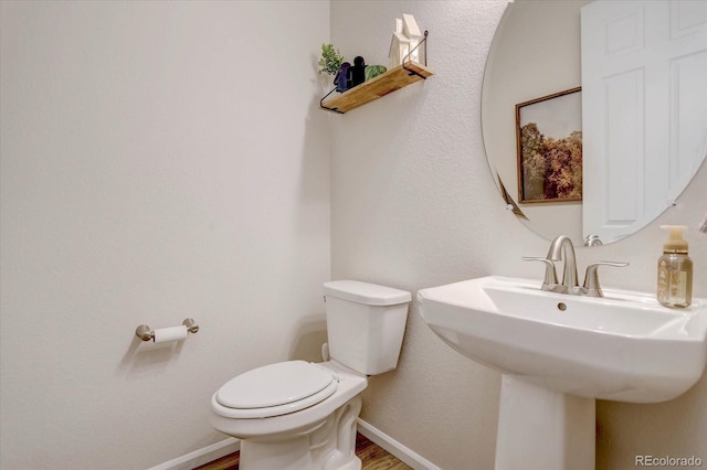 bathroom featuring hardwood / wood-style flooring and toilet