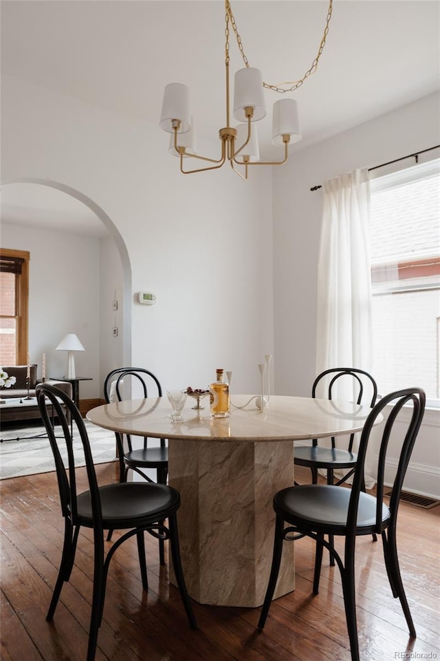 461 S Sherman St, Denver, CO 80209 - dining area with wood-type flooring, arched walkways, a chandelier, and plenty of natural light