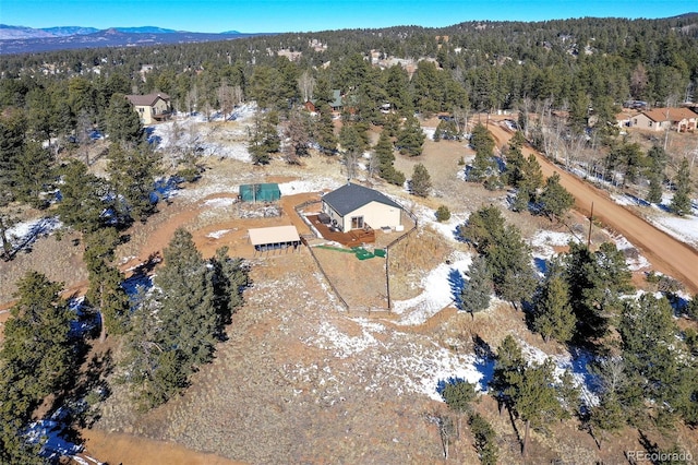 birds eye view of property featuring a forest view and a mountain view