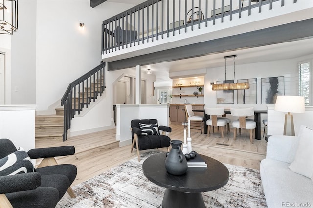 5814 Cole Way, Arvada, CO 80004 - living room with light wood-type flooring, a towering ceiling, and stairs