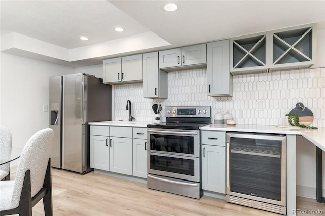 5814 Cole Way, Arvada, CO 80004 - kitchen with appliances with stainless steel finishes, beverage cooler, gray cabinetry, tasteful backsplash, and light countertops