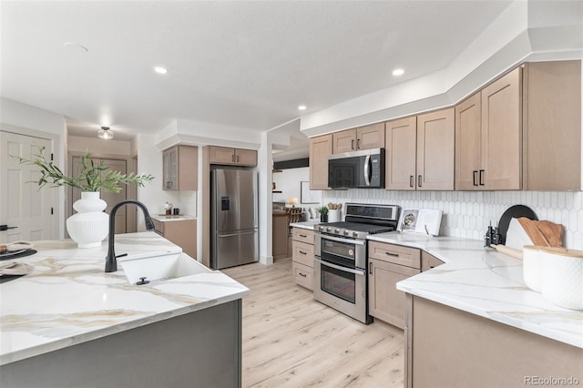 5814 Cole Way, Arvada, CO 80004 - kitchen with appliances with stainless steel finishes, light wood finished floors, backsplash, light stone countertops, and recessed lighting