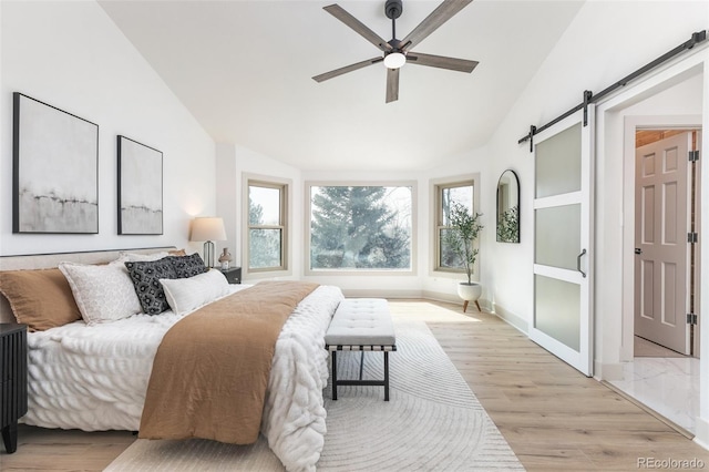 5814 Cole Way, Arvada, CO 80004 - bedroom featuring vaulted ceiling, a barn door, light wood finished floors, and ceiling fan