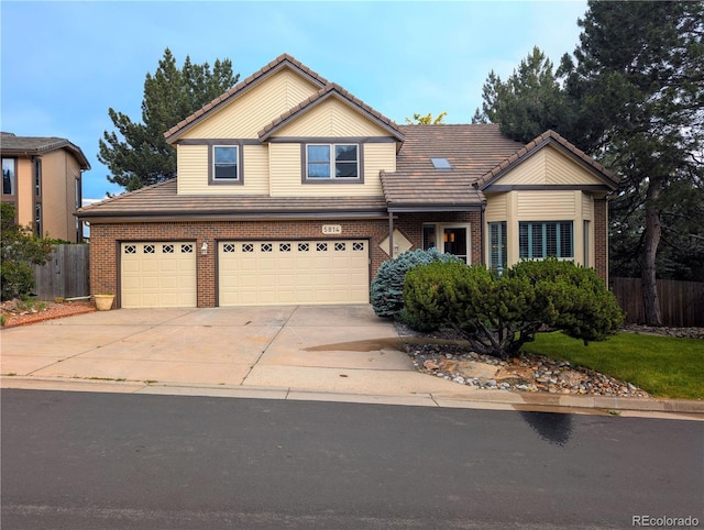 5814 Cole Way, Arvada, CO 80004 - view of front of home with a tiled roof, a garage, concrete driveway, and brick siding