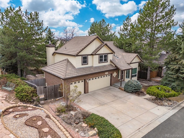 5814 Cole Way, Arvada, CO 80004 - traditional-style house with brick siding, concrete driveway, a tile roof, an attached garage, and a chimney