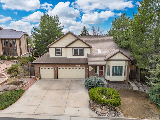 5814 Cole Way, Arvada, CO 80004 - view of front of home featuring brick siding, concrete driveway, an attached garage, and a tile roof