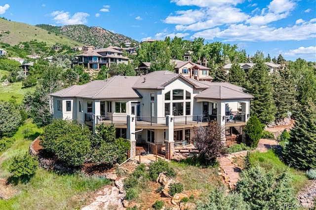 16134 Sandstone Dr, Morrison, CO 80465 - back of property with stucco siding, a tile roof, and a deck with mountain view