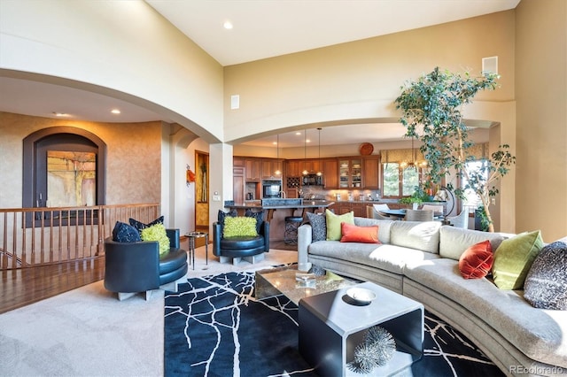 16134 Sandstone Dr, Morrison, CO 80465 - carpeted living area featuring arched walkways, recessed lighting, and a towering ceiling