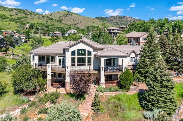 16134 Sandstone Dr, Morrison, CO 80465 - rear view of property with stucco siding, a tiled roof, a patio area, and stone siding