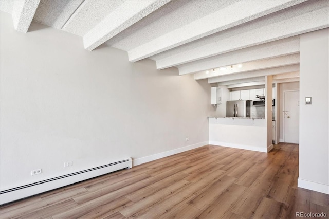 unfurnished living room featuring light wood-type flooring, beamed ceiling, and baseboard heating