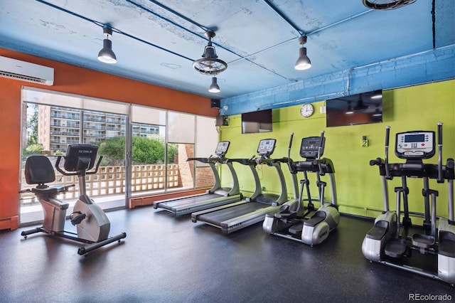 gym featuring a wealth of natural light and a wall mounted air conditioner