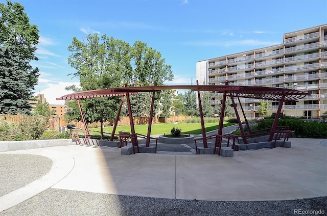 view of property's community with a patio, a lawn, and a pergola