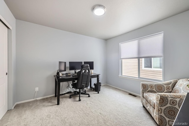 office area featuring baseboards, visible vents, and carpet